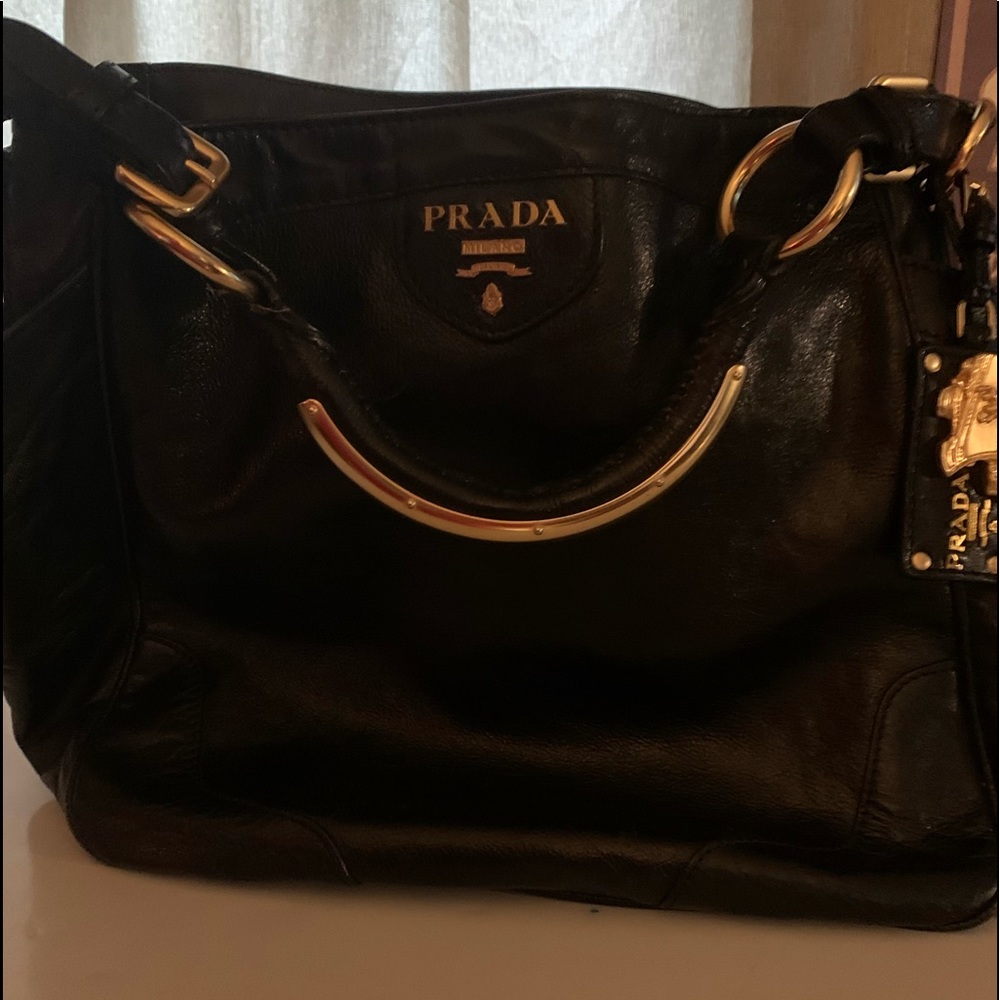 PRADA
Black Glace Calf Leather Tote Bag large side deep pockets.Gold trim handle